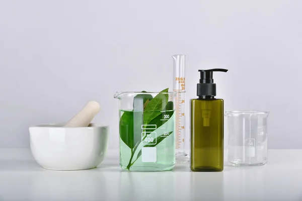 Natural skincare beauty product research, Organic botany extraction in scientific glassware at science laboratory, Blank cosmetic bottle container for branding mock-up.