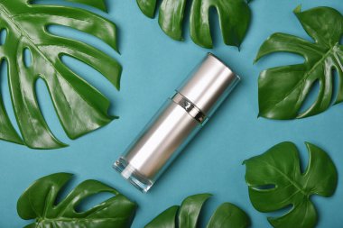 Yeşil bitkisel yapraklarla paketlenmiş kozmetik şişe kapları, organik markalaştırma için boş etiket, doğal cilt bakımı ürün konsepti.