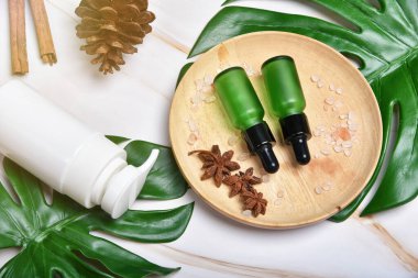 Yeşil bitkisel yapraklarla paketlenmiş kozmetik şişe kapları, organik markalaştırma için boş etiket, doğal cilt bakımı ürün konsepti.