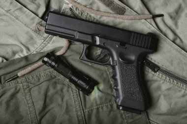 Ordu için taktik el feneri, yarı otomatik tabanca, yeşil üniformalı 9mm tabanca ve askeri teçhizat..