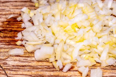 Koyu ahşap masaya yerleştirilmiş doğranmış soğanın ayrıntıları. Pişirme hazırlığı. Taze, diyet ve sağlıklı sebze..