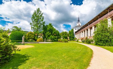 Lysice Kalesi, Çek Cumhuriyeti. 14. yüzyılda yapılmış ünlü bir barok kalesi. Güzel bir bahçe, palmiye ağaçları ve çiçekler. Şatonun yakınındaki güvertede. Güneşli bir gün, fırtınadan önce dramatik bulutlar.