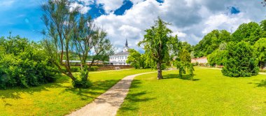Lysice Kalesi, Çek Cumhuriyeti. 14. yüzyılda yapılmış ünlü bir barok kalesi. Güzel bir bahçe, palmiye ağaçları ve çiçekler. Şatonun yakınındaki güvertede. Güneşli bir gün, fırtınadan önce dramatik bulutlar.