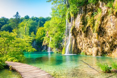Hırvatistan 'ın Plitvice milli parkındaki tahta patika. Gölün ve şelalenin yanındaki ormanda bir patika. Taze, güzel doğa, huzurlu bir yer. Ünlü turizm beldesi.