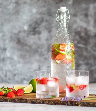 Tahta masaya çilekli ve limonlu taze içecek. Limonata ve buzlu bardaklar. Yaz içeceği.