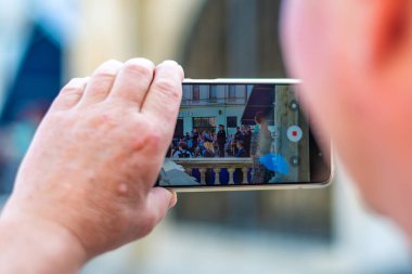 Brno, Çek Cumhuriyeti - 10.9.2021: Yaşlı adam polis söz töreninde cep telefonuyla fotoğraf çekiyor, Brno.