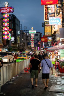 Bangkok, Tayland - 11.2025: Bangkok Çin Mahallesi 'ndeki Yaowarat Yolu boyunca yürüyen insanlar, parlak neon tabelalar, sokak yemekleri ve ünlü akşam pazarının atmosferiyle çevrili.