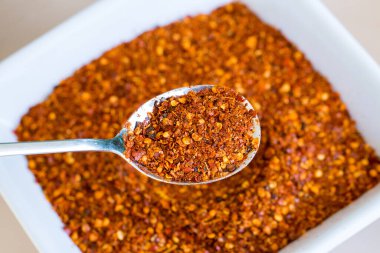 Kırmızı arkaplanda kırmızı biber kaşığı