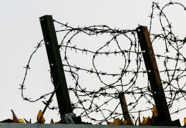 Koyu çitlerdeki dikenli teller. Tek renkli siluet fotoğraf