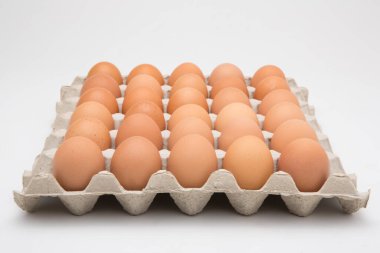 Kağıt tepsideki yumurtalar beyaza izole edilmiş.