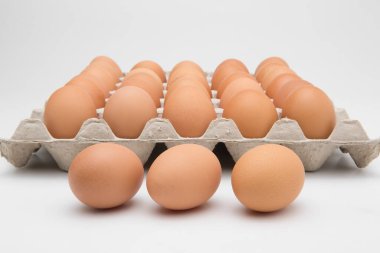 Kağıt tepsideki yumurtalar beyaza izole edilmiş.
