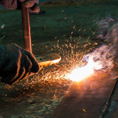 Bir tamirci çeliği kıvılcımlarla dolduruyor..