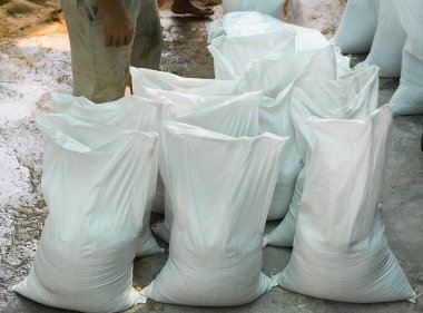 Kum torbaları sel sularını kasabanın sel korumasından uzak tutmaya yardımcı olur.