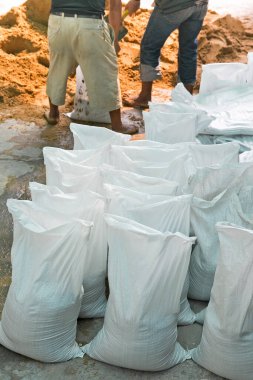 Kum torbaları sel sularını kasabanın sel korumasından uzak tutmaya yardımcı olur.
