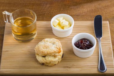 Çay, çaydanlık, çay, reçel, ekmek ve bal ile kahvaltı masası.