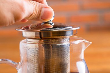 Çay, çaydanlık, çay, reçel, ekmek ve bal ile kahvaltı masası.