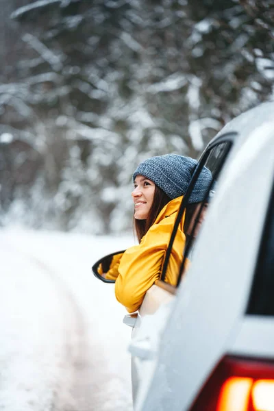 Улыбающаяся Молодая Девушка Путешественница Смотрит Сторону Зимнего Леса Окон Автомобиля — стоковое фото