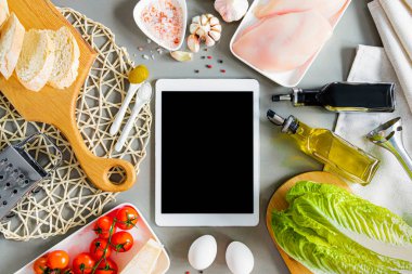 Sezar salatası, tavuk göğsü, kızarmış ekmek, zeytinyağı, sos, yumurta, sarımsak, vişneli domates, hardal, şeker ve tuz yapmak için bir set ürün. Reçete defteri