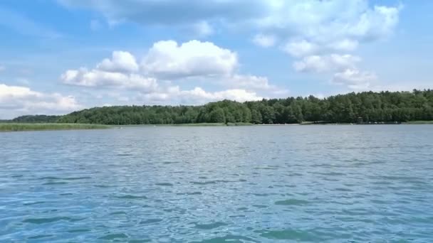 Een grote, brede, blauwe rivier tegen een blauwe lucht met grote wolken op een zonnige dag. Plaats voor visserij en recreatie — Stockvideo