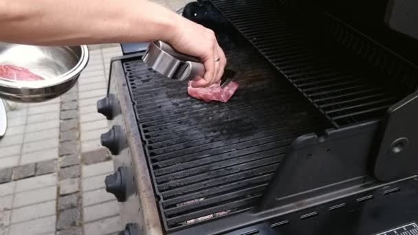 Masculino fríe la carne fresca en una parrilla de gas — Vídeo de stock