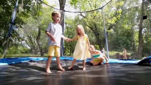 행복 한 아이들은 공원의 트램펄린에서 재미있게 뛰놀고 있다 — 비디오