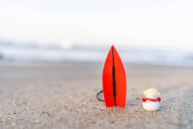 Sandy Christmas Snowman dalgaları izliyor, güzel bir plajda duruyor Patong Beach, Phuket, Tayland 'da yatay bir sörf tahtasıyla