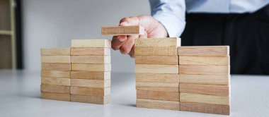 İş dünyasında plan ve strateji, İş Büyütme Riski Ahşap bloklar ile İş Büyüme Konsepti, insan eli yığılır ve ahşap bir blok istifleme.