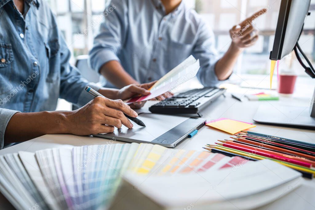 Young colleagues designers working together on a creative project and color samples for selection, Color swatch samples, Brainstorming Planning Partnership, creative graphic design working desktop.