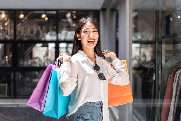 アジアの女の子の肖像興奮美しい女の子幸せな笑顔で開催ショッピングバッグリラックスした式 正の感情ショッピング ライフスタイルの概念 — ストック写真