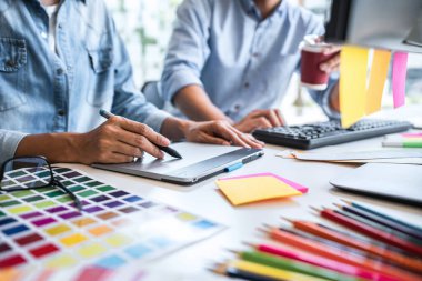 Yaratıcı bir proje üzerinde birlikte çalışan genç iş arkadaşları ve renk örnekleri, renk örnekleri, Beyin Fırtınası Planlama Ortaklığı, masaüstünde çalışan yaratıcı grafik tasarımı.