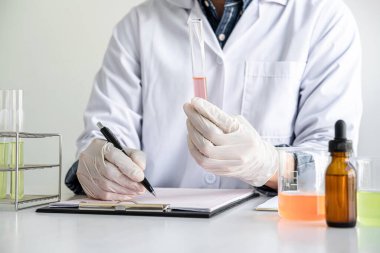 Biyokimya laboratuvarı araştırması. Kimyager laboratuvarda kimyasal sıvı içeren ekipman ve bilimsel deneylerle numune analiz ediyor..