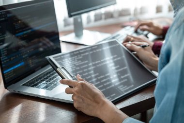 Asyalı kadın programcı, yeni bir web sitesi ya da yazılım geliştirme bürosundaki uygulama için kod yazarken, yeni proje hakkında partneriyle kod verileri tutuyor ve tartışıyordu.
