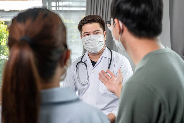 Mann Arzt Mit Medizinischer Gesichtsmaske Zum Gespräch Mit Jungen Paar — Stockfoto