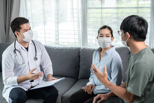 Mann Arzt Mit Medizinischer Gesichtsmaske Zum Gespräch Mit Jungen Paar — Stockfoto