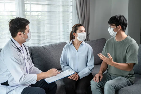 Man Läkare Medicinsk Ansiktsmask Till Samtal Med Unga Par Medan — Stockfoto