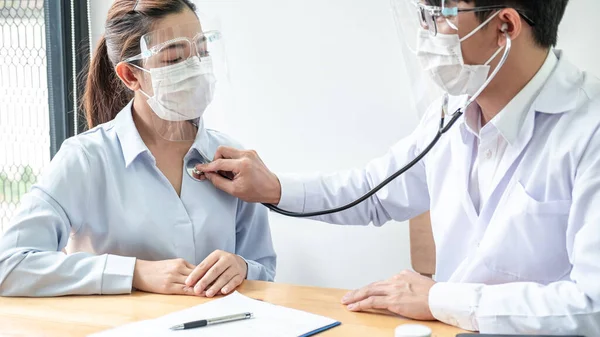 Manlig Läkare Medicinsk Mask Använder Stetoskop För Att Undersöka Hjärtslag — Stockfoto