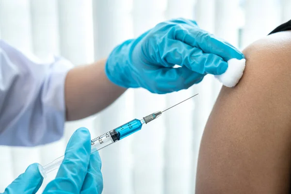 장갑을 주사기를 의사가 환자의 어깨에 코로나 바이러스 백신을 투여하기 목화를 — 스톡 사진