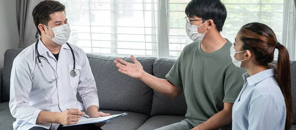 Mann Arzt Mit Medizinischer Gesichtsmaske Zum Gespräch Mit Jungen Paar — Stockfoto