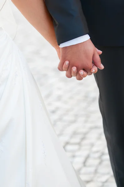 Bride and groom holding hands — Stock Photo, Image