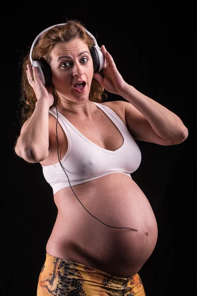 Pregnant woman with headphones listening — Stock Photo, Image