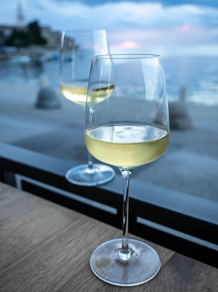 Due bicchieri di vino bianco con tramonto sul mare sullo sfondo. — Foto Stock