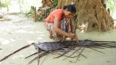 HIRIWADUNNA, SRI LANKA, 10 Mart 2019 - Genç Asyalı kadın palmiye çatısı yapıyor.