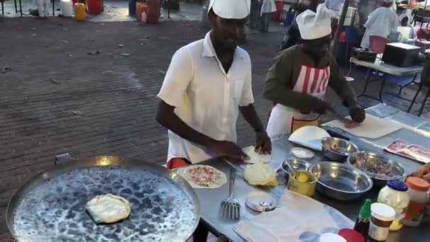Каменный город, ЗАНЗИБАР, 20 февраля 2020 года - Мужчины, готовящие на рынке Занзибарскую пиццу — стоковое видео