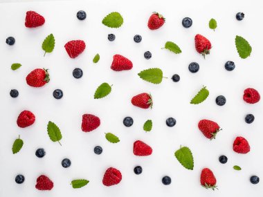Beyaz arka planda çilek, yabanmersini, ahududu ve taze nane yaprakları. Düğüm konsepti.