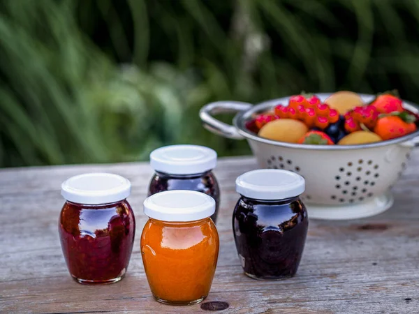 Four Jars Homemade Jam Blackberries Strawberries Apricots Wooden Table Garden — Stock Photo, Image