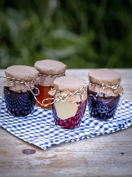 Four Jars Homemade Jam Blackberries Strawberries Apricots Table Garden Paper — Stock Photo, Image