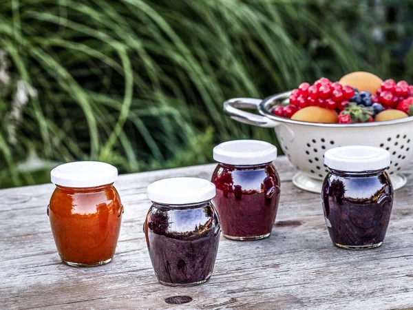Four Jars Homemade Jam Blackberries Strawberries Apricots Wooden Table Garden — Stock Photo, Image