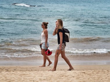 MIRISSA, SRI LANKA - 17 Mart 2019: Kumsalda yürüyen dövmeli iki beyaz kadın.