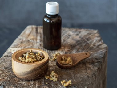 Propolis tüpü, ahşap kase ve bir kaşık propolis granülü..