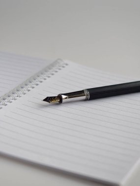 Beyaz spiral defter ve dolmakalem. Uzayı kopyala Dikey çekim.